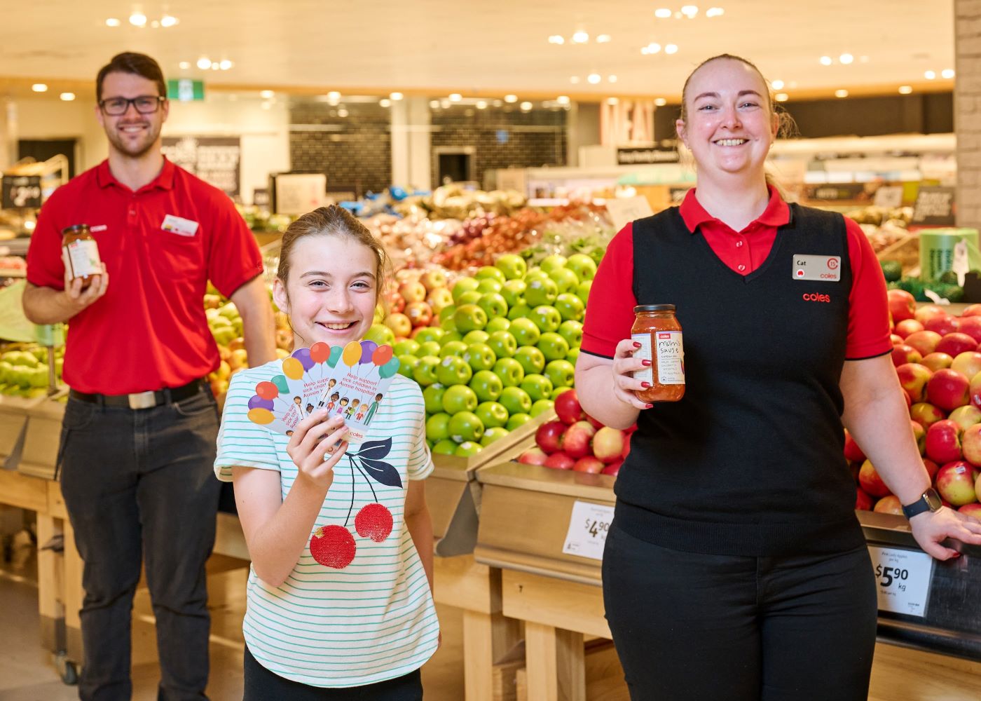 Mary Rogers, 10 ,with Coles Melville Team Members Matt and Cat and the $2 Curing Homesickness donation cards